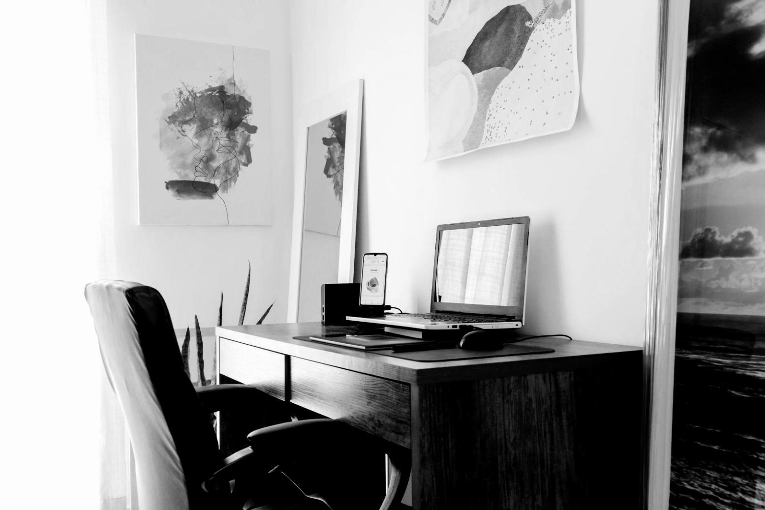 Office workspace with budget planning documents and laptop displaying financial dashboards